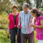 Woman accompanying her elderly parents on a walk in the countryside. Active aging and family support