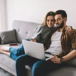 smiling spouse watching video via computer